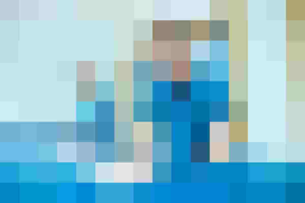Eine Ausbilderin des Textil- und Reinigungsservices zeit einem Jugendlichen die Bügelmaschine