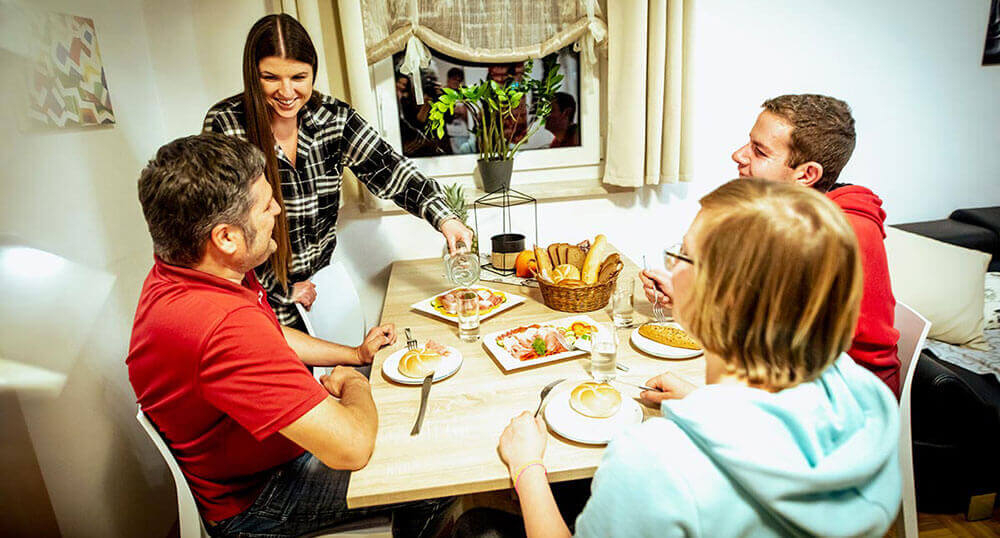 Betreuerin bereitet mit Bewohnern Abendbrot zu