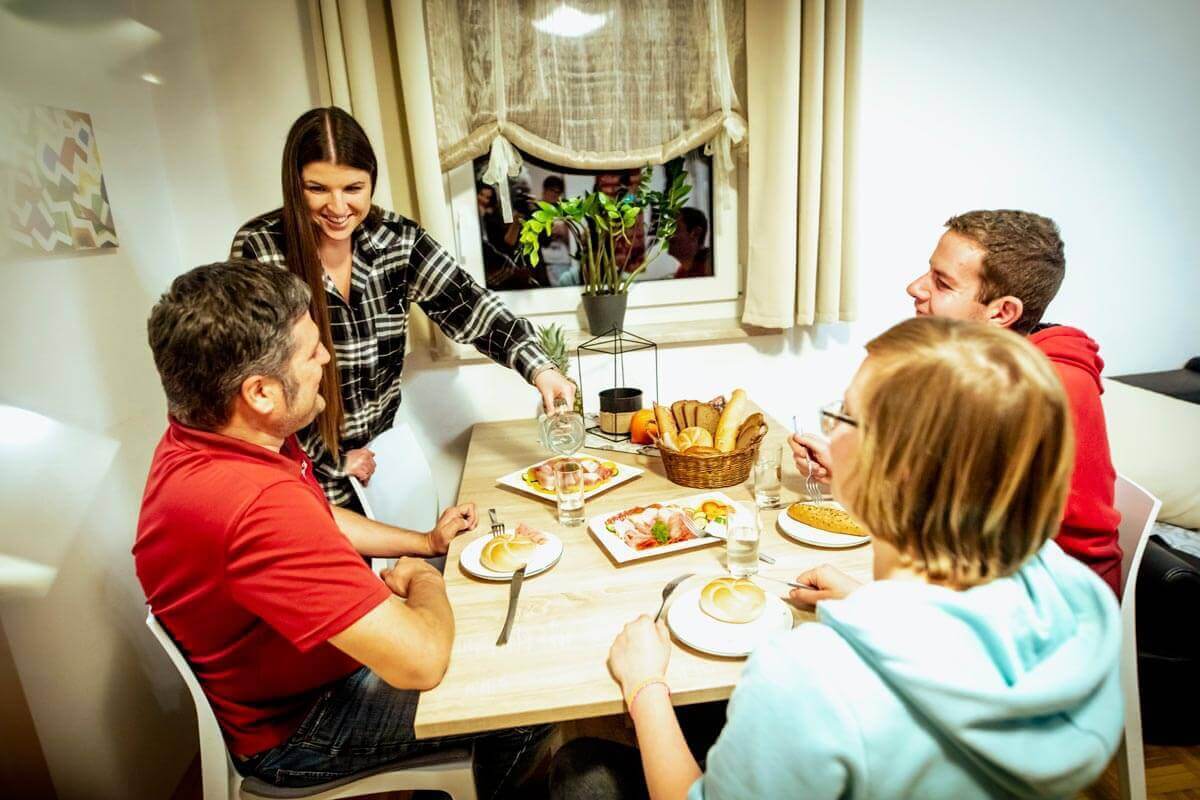 Wohnbetreuerin bereitet mit Bewohnern Abendbrot zu