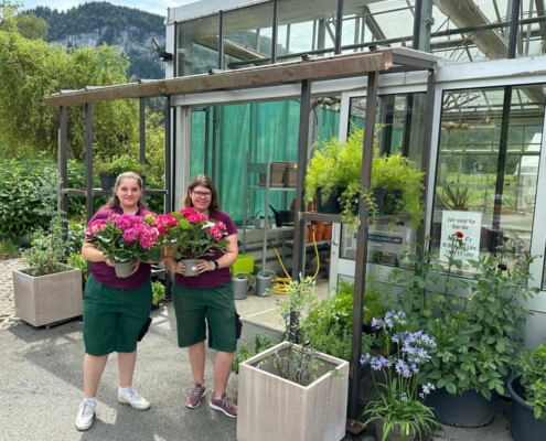 Zwei Jugendliche aus dem Gartencenter dekorieren das neue Vordach am Campus von oberrainanderskompetent