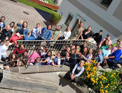 Gruppenfoto der Jugendlichen und MitarbeiterInnen von oberrainanderskompetent auf einer Treppe sitzend