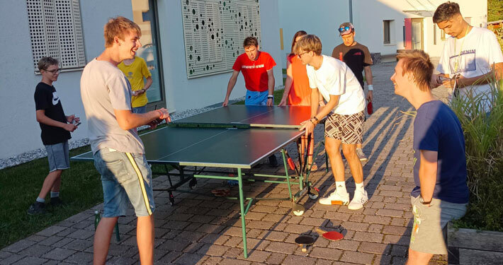 Ausbildung-bei-oberrainanderskompetent_Willkommensparty_Beitragsbild Jugendliche am Campus oberrain bauen eine Tischtennisplatte auf