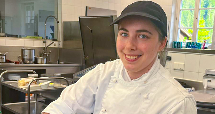 Junge Köchin in weißer Uniform in einer Küche