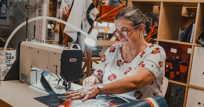 Frau näht Tasche aus buntem Ski-WM-Banner