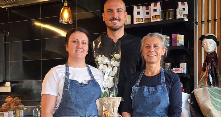 Drei Personen in Arbeitskleidung in einer Küche